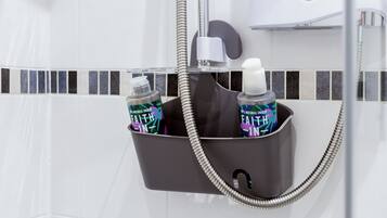 Area doccia con porta asciugamani nero che contiene due flaconi di shampoo e balsamo 'Faith-in'.