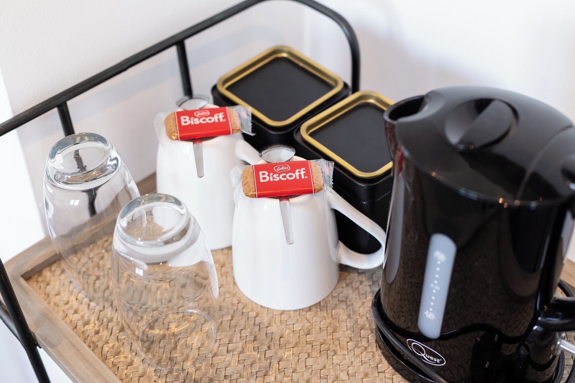 A tray with a coffee maker, two glass containers, and two white pitchers with Biscoff labels.