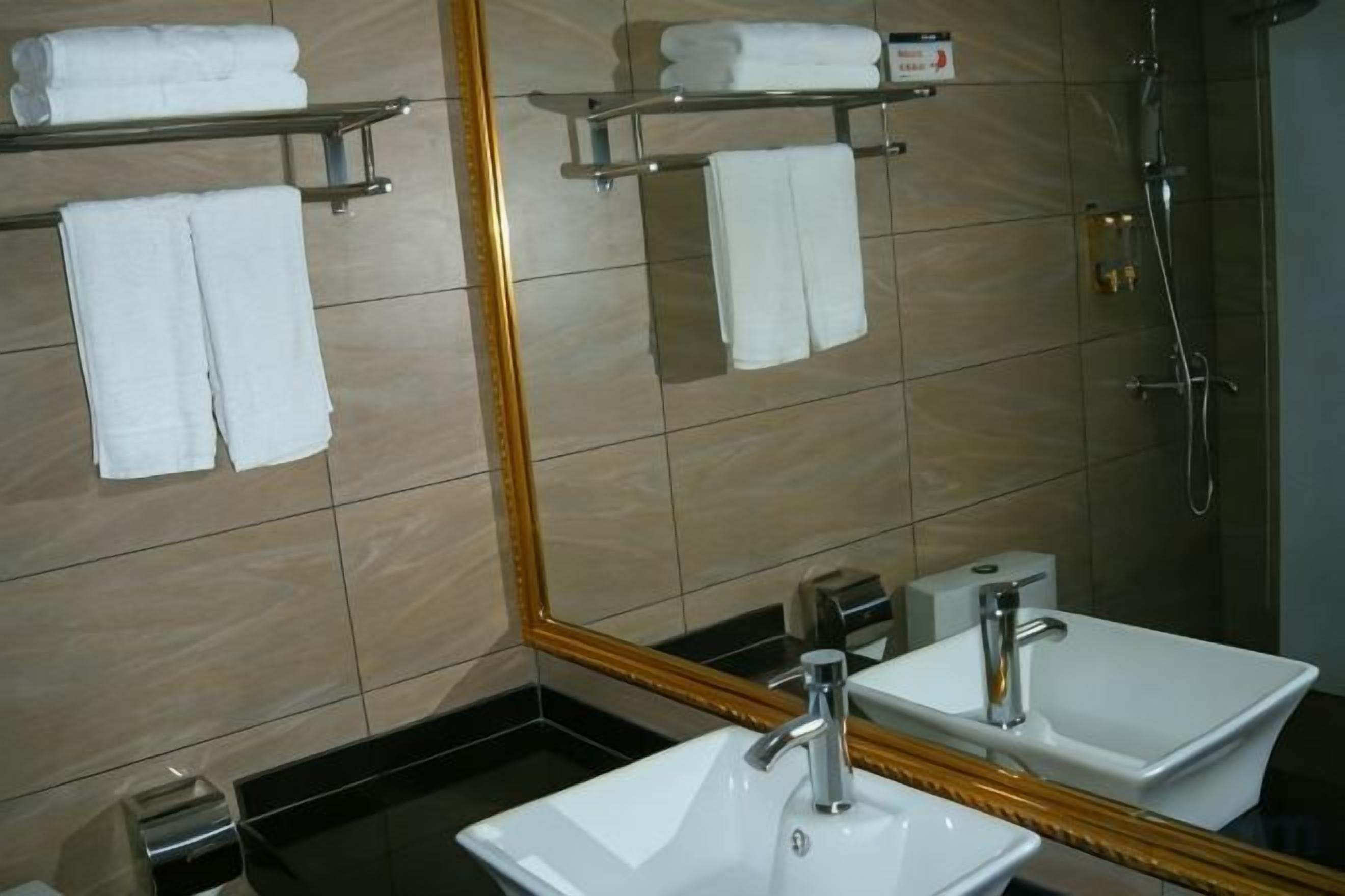 A bathroom with a sink, mirror, and towel rack.
