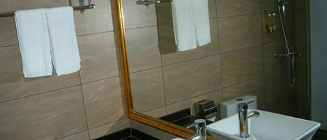 A bathroom with a sink, mirror, and towel rack.