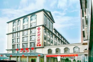 A multi-story building with a prominent entrance and signage. - Wu Zhou Hotel (Debao)