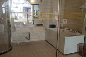 Une salle de bain moderne avec une douche à l’italienne en verre, un lavabo blanc et une baignoire.