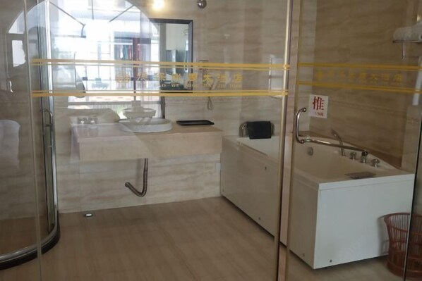 Un baño moderno con cabina de ducha de vidrio, un lavabo blanco y una bañera.