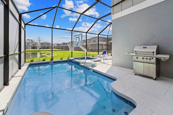A swimming pool with a view of a backyard, a grill, and a basketball hoop.