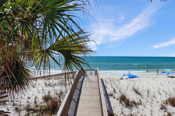 A wooden boardwalk leading to a beach with palm trees and a clear blue sky. - Direct Beach Access, Pet Friendly & Pool (Cape San Blas)