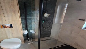 A modern bathroom with a glass shower enclosure, a toilet, and a bidet. - Holiday homes close to the seaside beach (Sarbinowo)