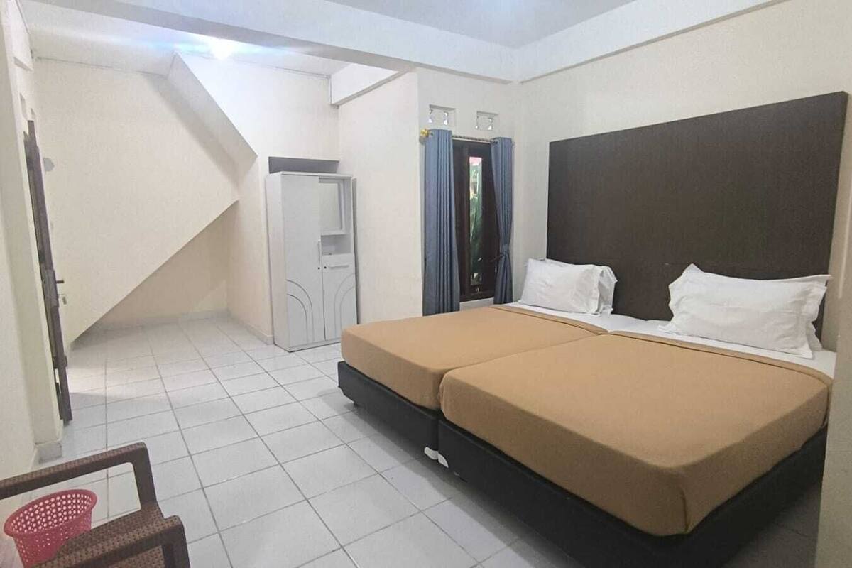 Una camera da letto con un letto, una sedia, un armadio e una scala.