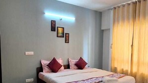 Ein geräumiges Schlafzimmer mit einem großen Bett, einem Deckenventilator und Blick ins Freie durch Vorhänge.