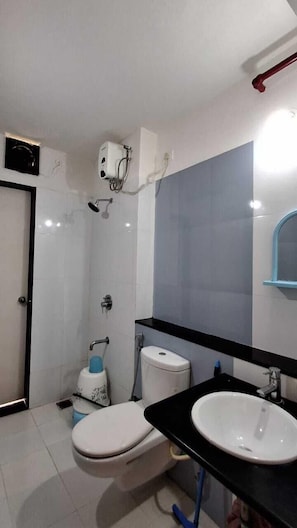 Un baño con inodoro, lavabo y ducha.