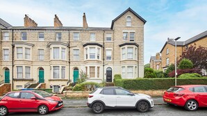 Une rangée de maisons mitoyennes avec une voiture blanche garée devant.