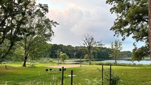 A park with picnic tables, a lake, and a grassy area with trees. - Camp Blue Canoe - Creekside Cottage  (Three Rivers)