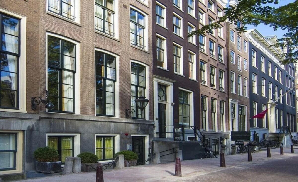 A row of brick buildings with large windows and a red flag.