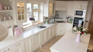A kitchen with white cabinetry, a central island, and a microwave.