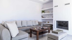 Ein modernes Wohnzimmer mit einer Eckcouch, einem Holztisch und einem Kamin.