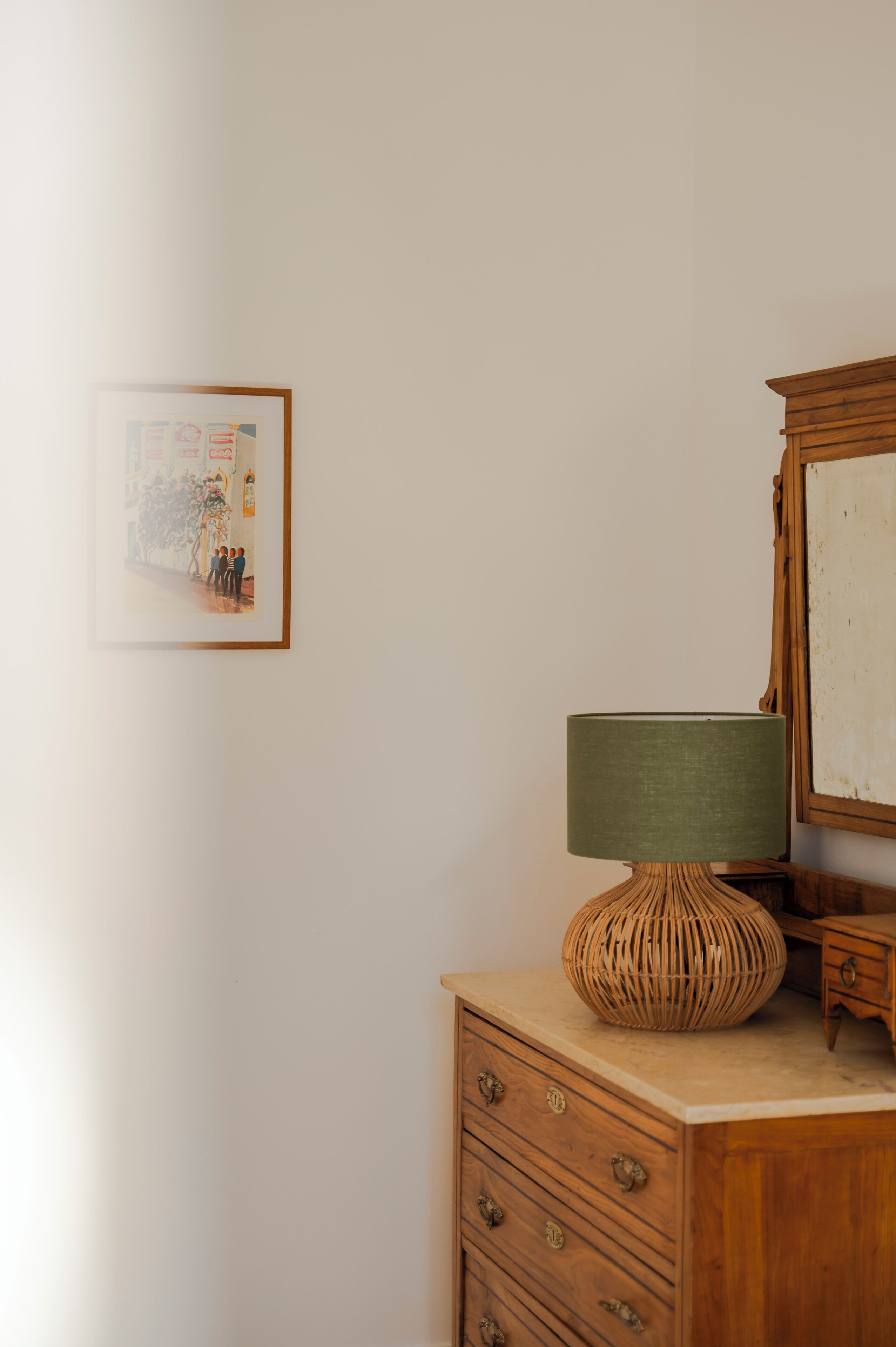 Ein Holzkapfen mit einer gewobenen Lampe und einem gerahmten Bild an der Wand.