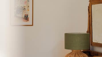 Ein Holzkapfen mit einer gewobenen Lampe und einem gerahmten Bild an der Wand.