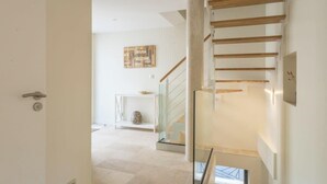 A modern interior with a staircase, a glass railing, and a minimalist decor. - Le Havre des Calanques - Morgiou - Piscine - Terrain de pétanque (Marseille)