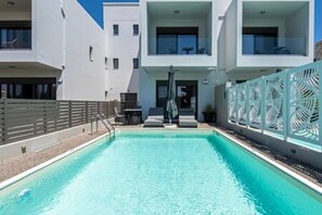 A modern hotel with a swimming pool, outdoor seating, and a white facade. - Villa Kares II by Estia (Kos)