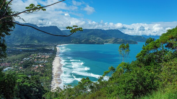 A coastal landscape with a beach, mountains, and a clear sky. - Pousada Aysu Maresias (São Sebastião)