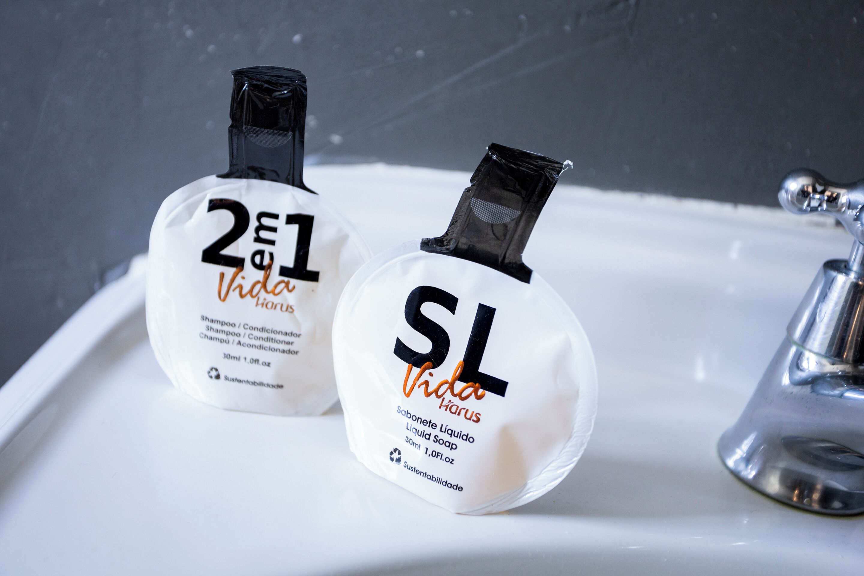 Two bottles of shampoo and conditioner on a bathroom sink.