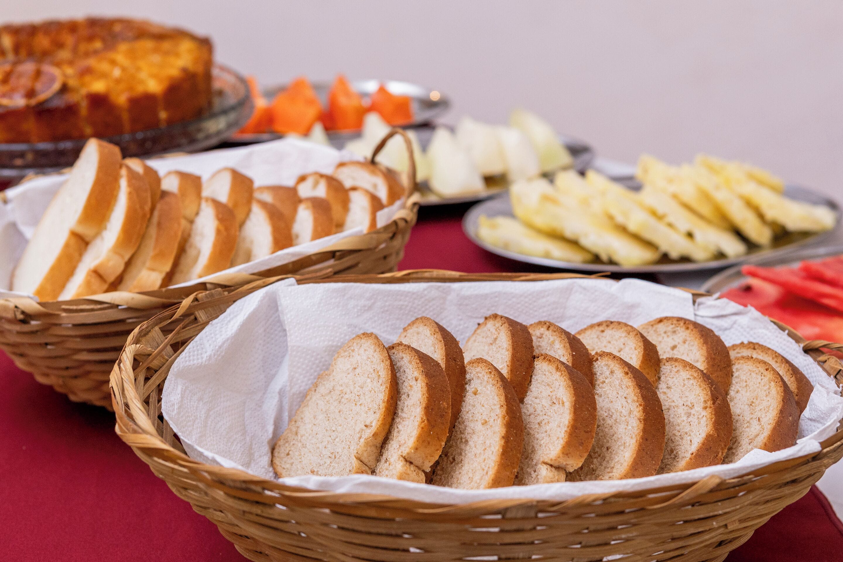 A table with various food items including bread, fruit, and a cake.