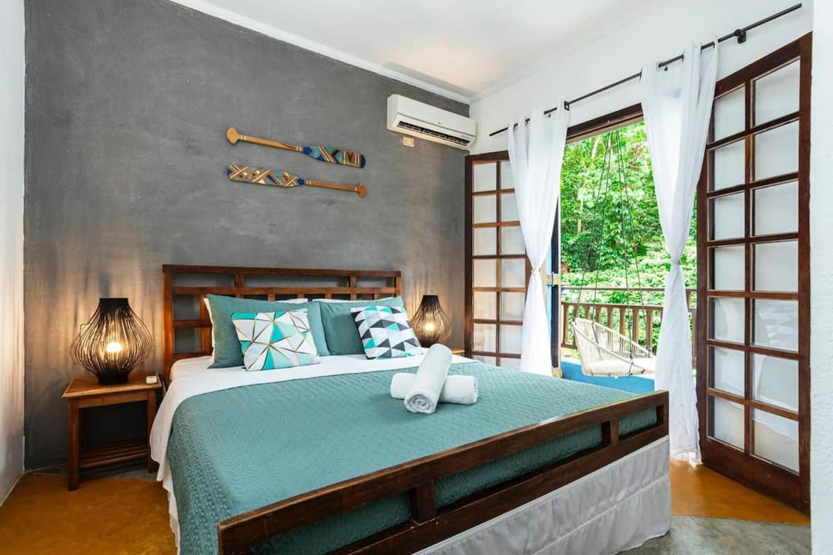 A bedroom with a bed, nightstands, and a window with curtains.