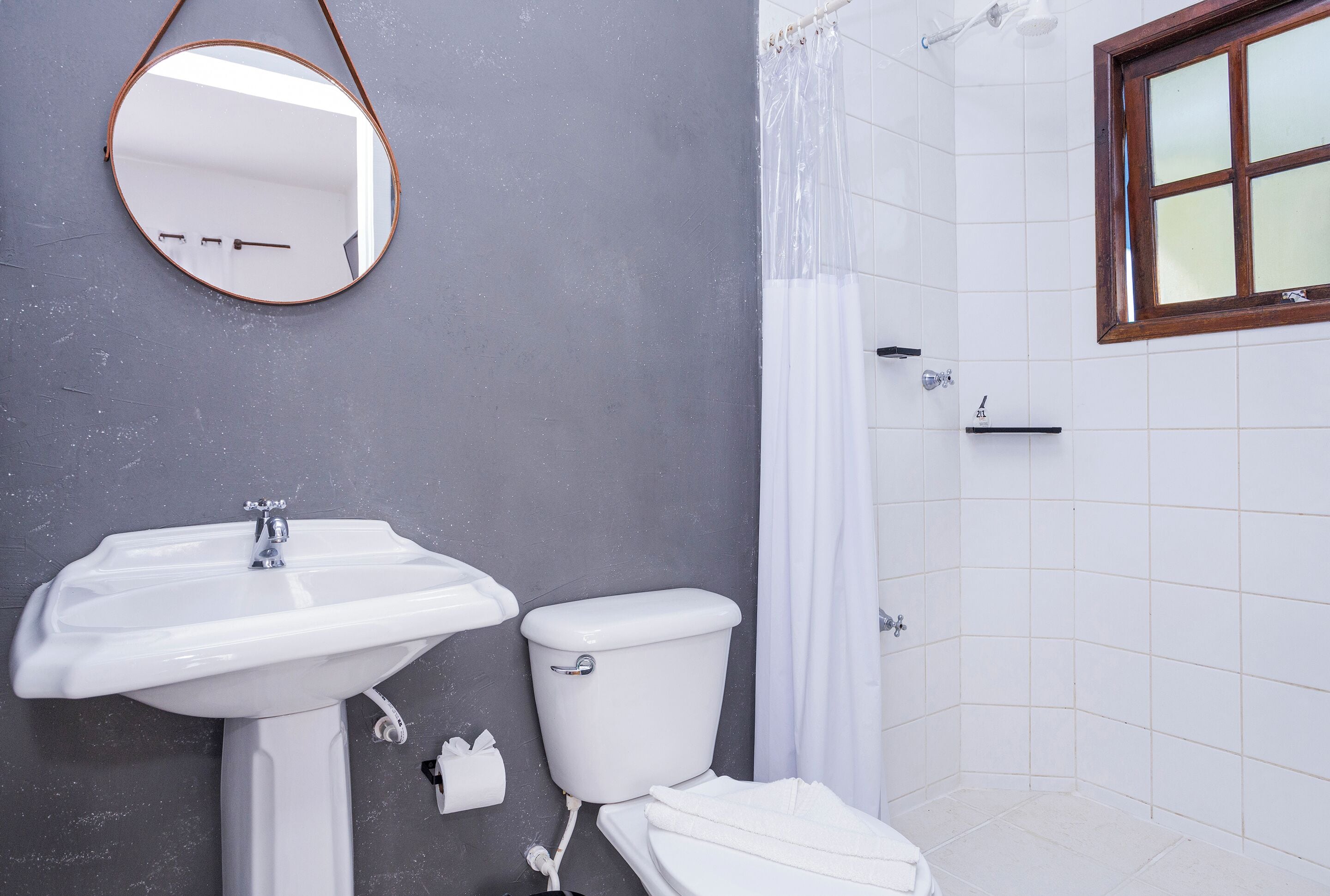 A bathroom with a white sink, toilet, and shower curtain.