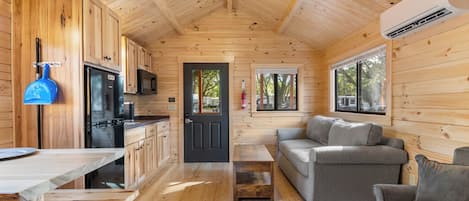 L’intérieur d’un chalet en bois comprend une cuisine, un coin repas et un salon.