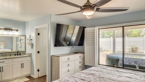 A bedroom with a bed, a ceiling fan, a dresser, a TV, and a large window. - Private Hot Tub: Show Low Home 3 Mi to Lake (Show Low)
