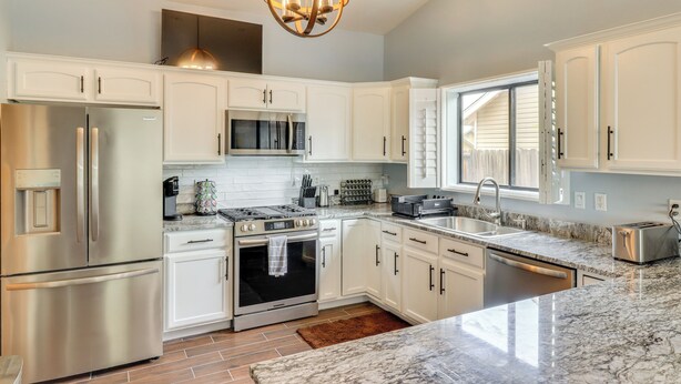 A modern kitchen with white cabinets, stainless steel appliances, a marble countertop, and a pendant light. - Private Hot Tub: Show Low Home 3 Mi to Lake (Show Low)