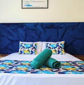 Relax in comfort with a large bed, colorful bedspread, and framed quote on the wall.