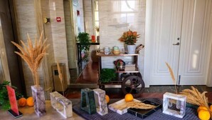 A reception area with marble decor, a plant shelf, and a decorative wheel. - Nantong White-collar INN (Nantong)