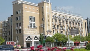 A multi-story hotel with a prominent clock tower and a sign indicating it is a hotel. - Nantong White-collar INN (Nantong)