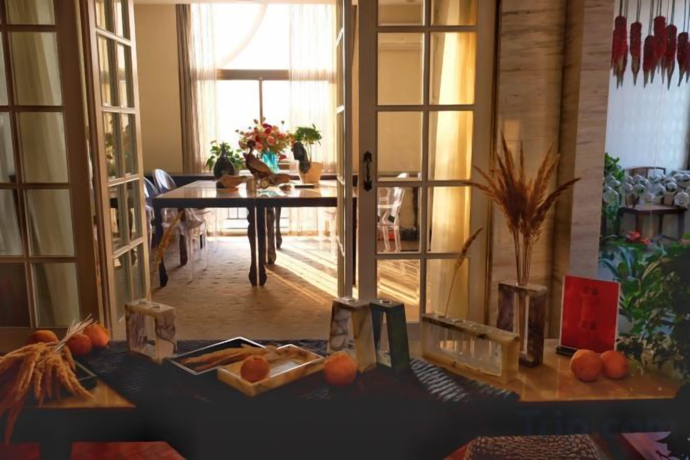 Una habitación con una mesa de comedor, sillas y vistas a través de un ventanal.