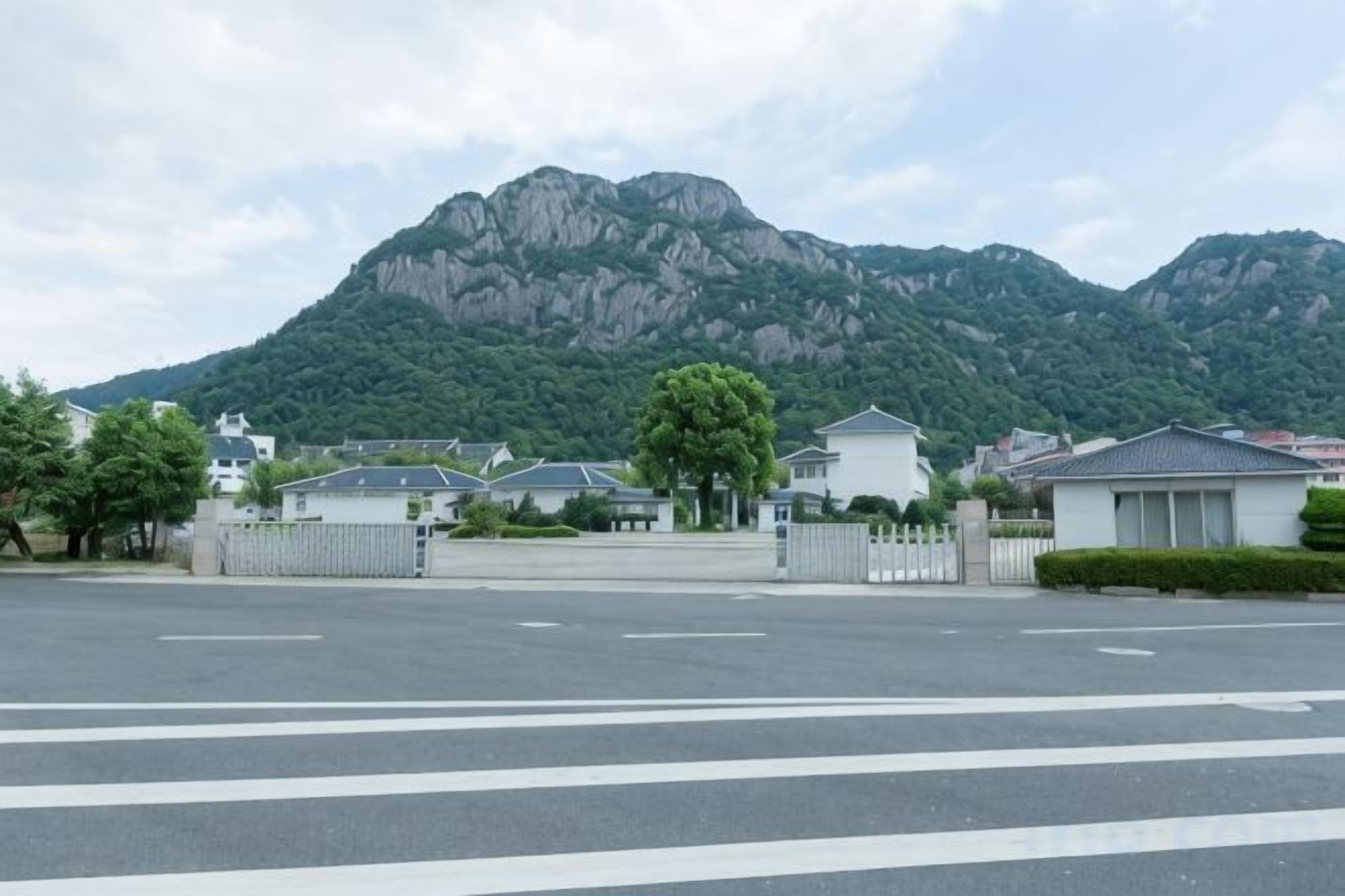 A parking lot with houses and a mountain in the background.