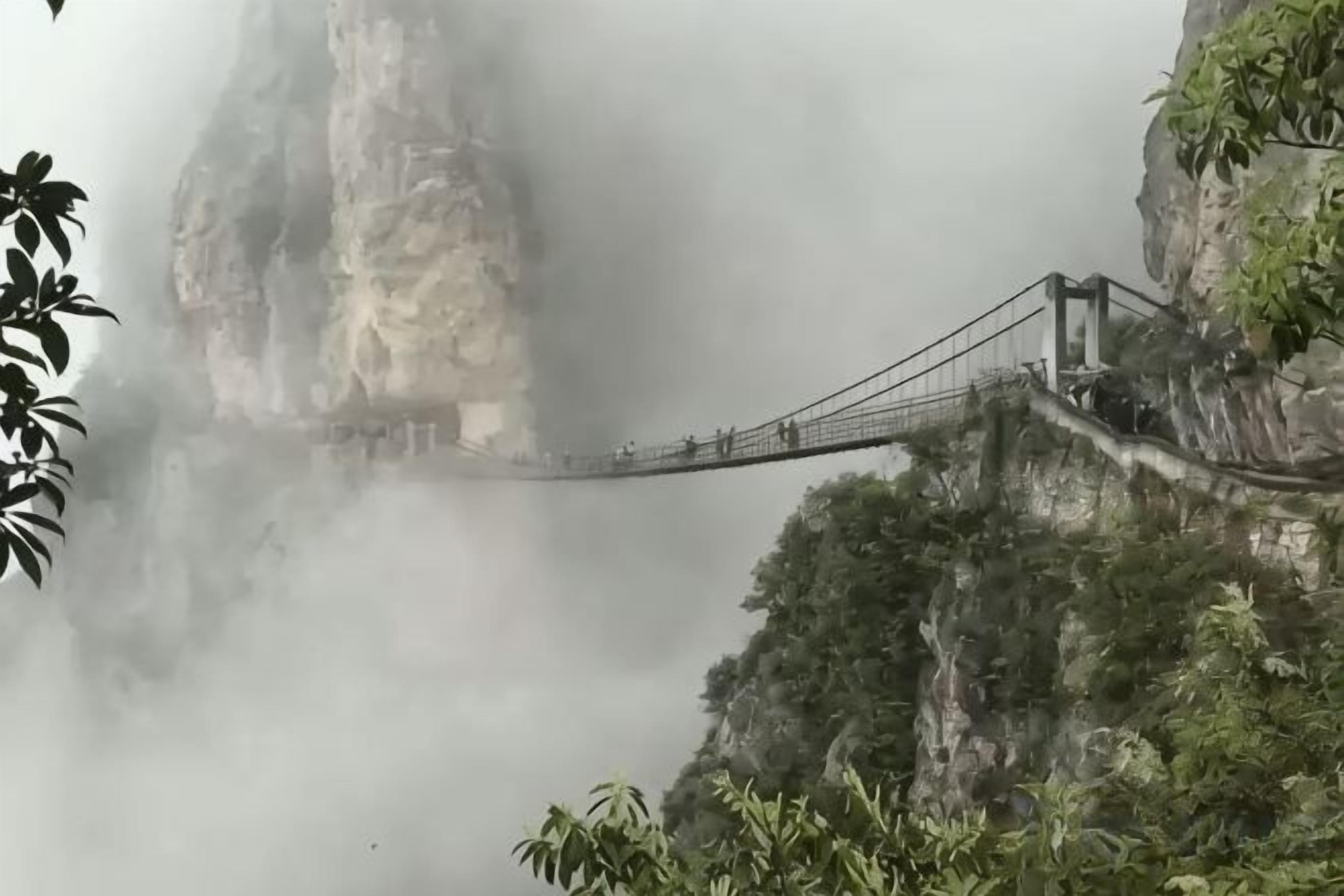 Un pont suspendu surplombant une falaise embrumée.