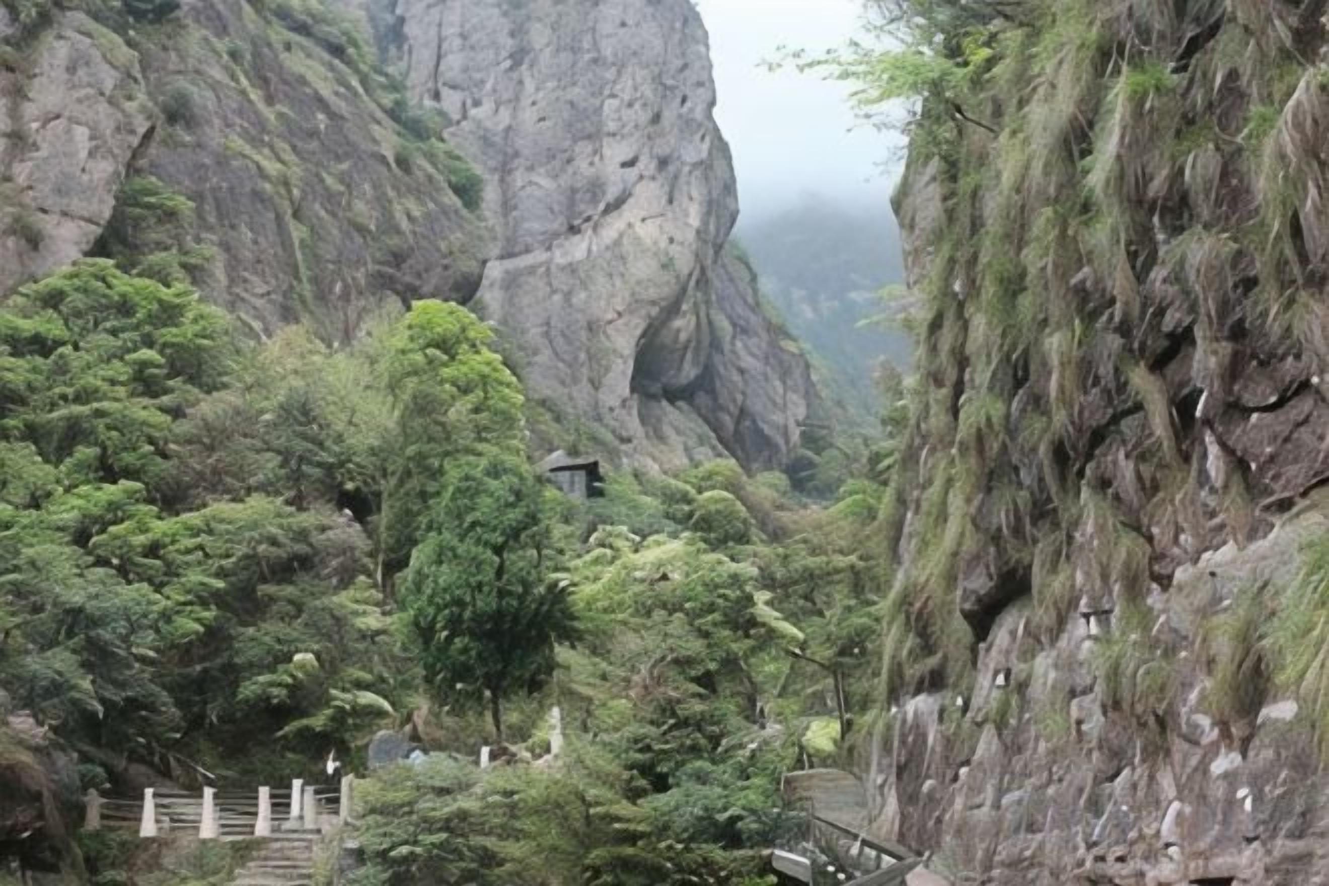 A mountainous landscape with a wooden staircase leading up to a structure.