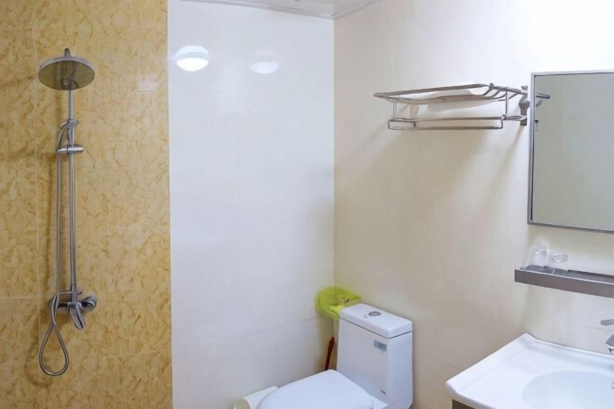 Ein Badezimmer mit Dusche, Toilette, Waschbecken und Handtuchhalter.