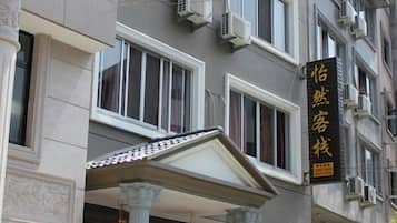 A multi-story building with a classical architectural style, featuring columns and a balcony.