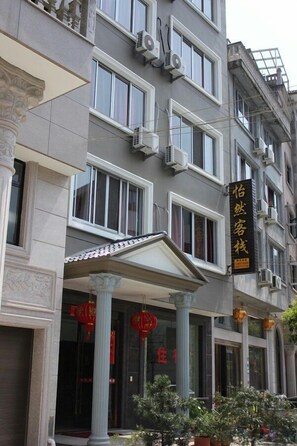 A multi-story building with a classical architectural style, featuring columns and a balcony. - yiranju (Yueqing)