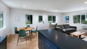 Una cocina moderna con comedor, sofá y una pequeña mesa.