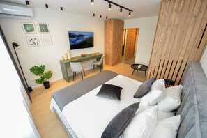 Une chambre à coucher moderne avec un lit, un bureau et un téléviseur.