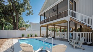 A two-story house with a pool, outdoor seating, and a covered patio area. - Heads Carolina: Modern Home with Private Pool in Quiet Neighborhood (Oak Island)
