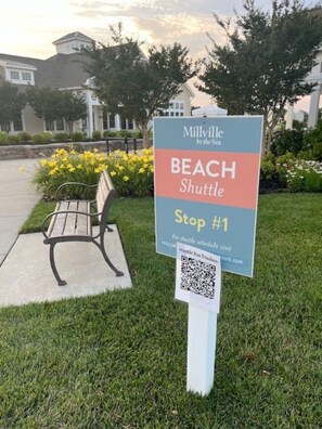 A sign for a beach shuttle stop with a QR code for shuttle schedule. - Welcome to Sunkissed located minutes from Bethany Beach! (Millville)
