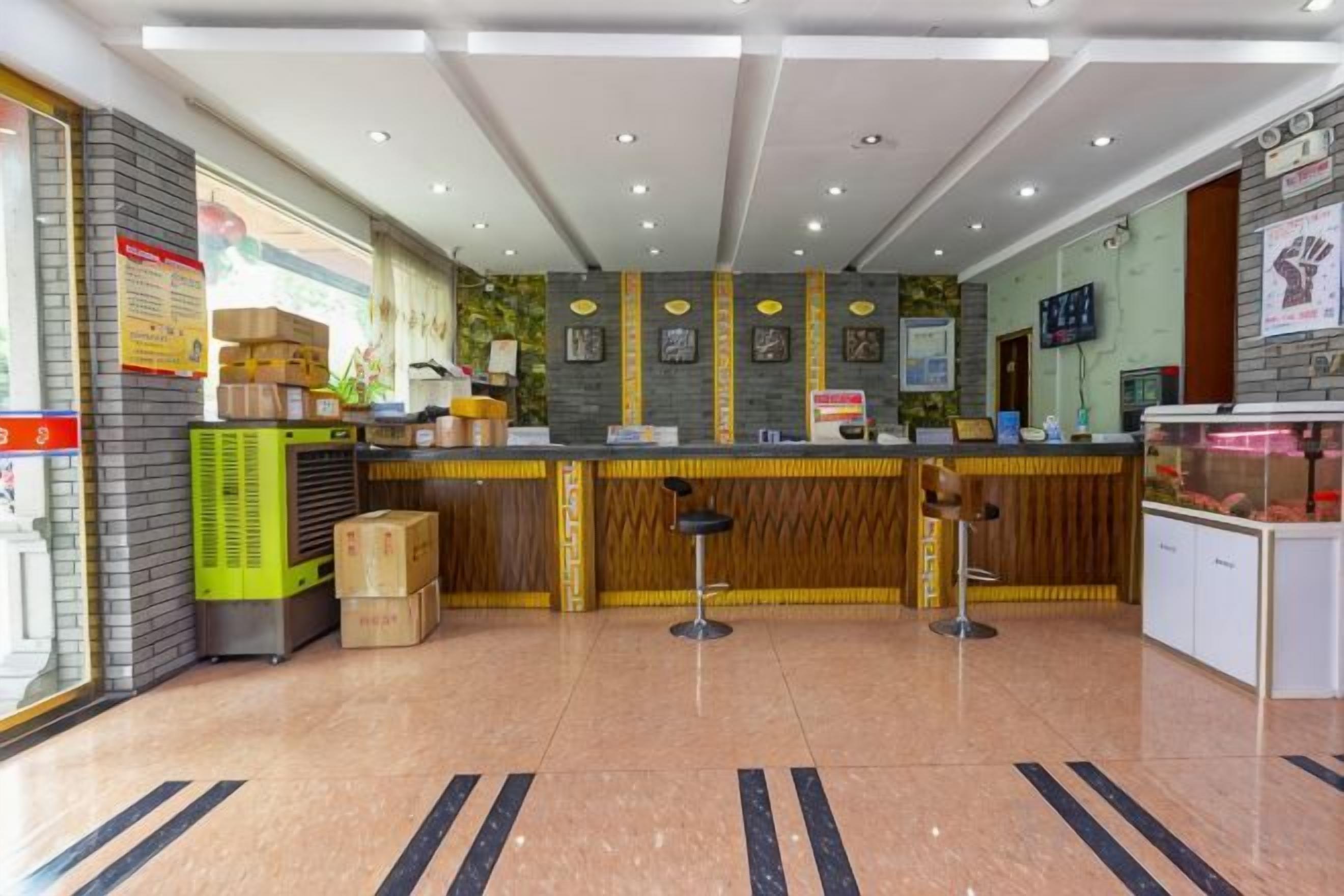 Un espace d’accueil d’hôtel comprenant un comptoir, des sièges et une vitrine.