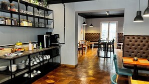 A modern kitchen with a coffee station, dining area with a booth, and a view of the living room. - Tinka     (Santiago)