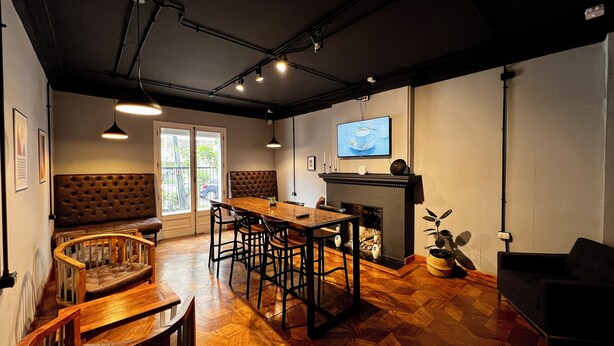Un comedor con mesa y sillas de madera, un sofá y una chimenea.