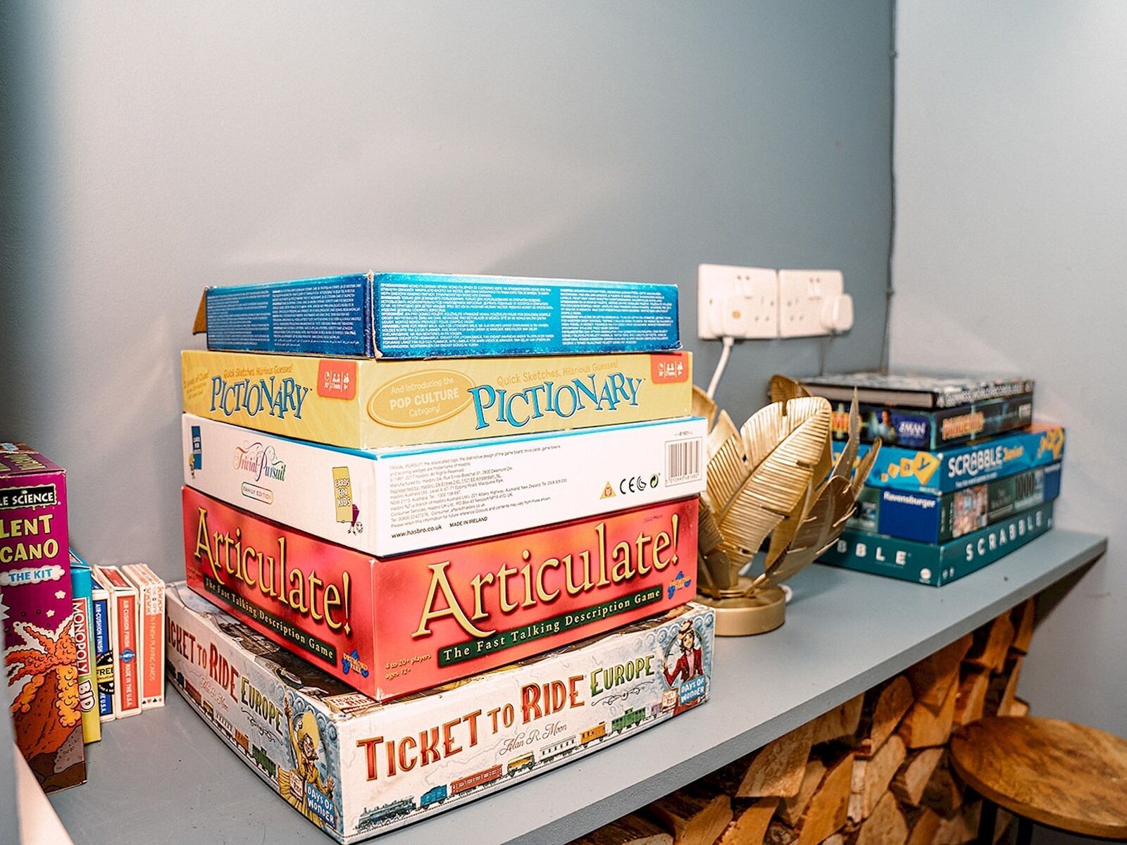 A collection of board games on a shelf, including 'Ticket to Ride Europe' and 'Articulate!'