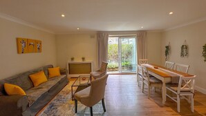 Un salon spacieux avec un canapé, un fauteuil et une table à manger.