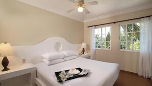 A hotel room with a large bed, two bedside tables with lamps, a ceiling fan, and a window with curtains. - Presidential Junior Suite - Cabarete (Puerto Plata)